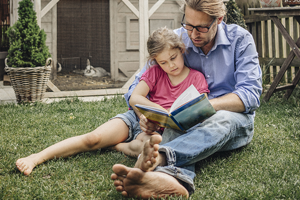 creative ways to summer reading 2585 - father reading to daughter while sitting on the grass