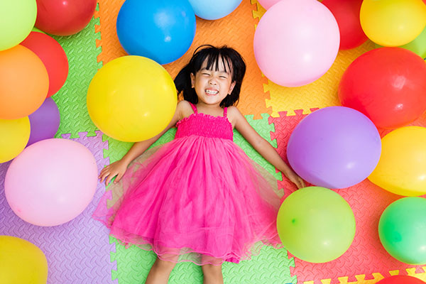 girl playing in a bunch of balloons