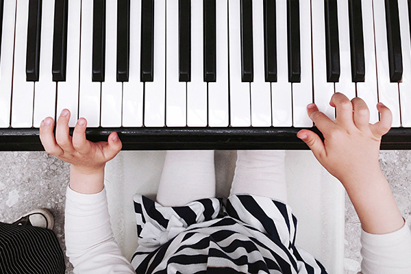 Closeup of child's hands playing the piano