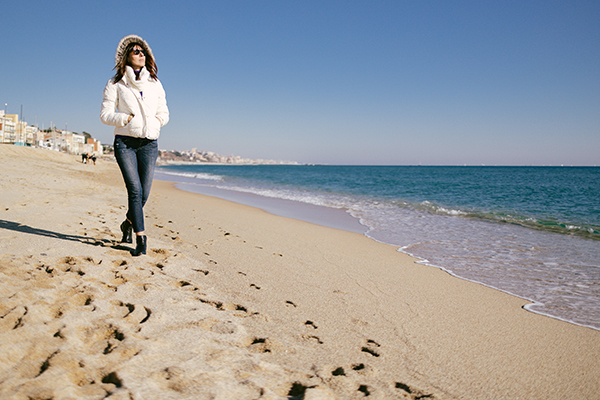 Mature woman walking on the beach on a sunny winter day