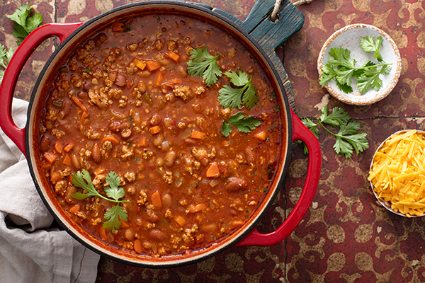 Traditional chili soup with meat, vegetables and red beans in a dutch oven