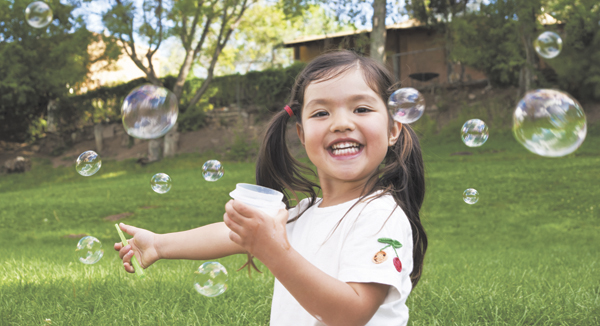 girl blowing bubbles